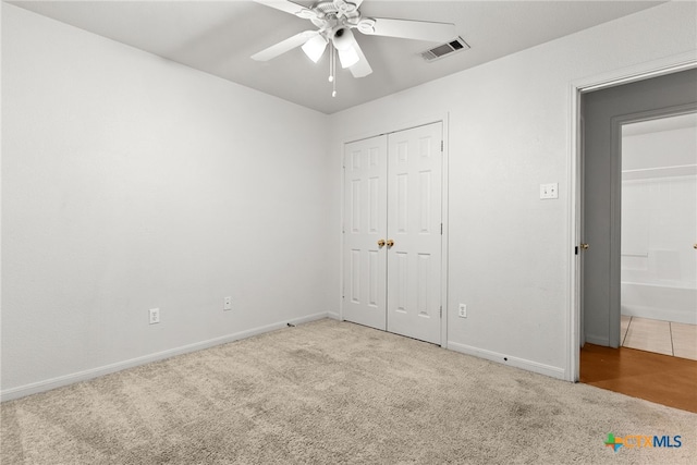 unfurnished bedroom featuring light carpet, a closet, visible vents, and baseboards