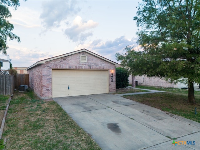 ranch-style house with cooling unit, a garage, an outbuilding, and a front yard