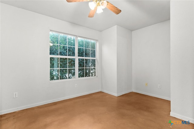 spare room featuring ceiling fan and concrete floors