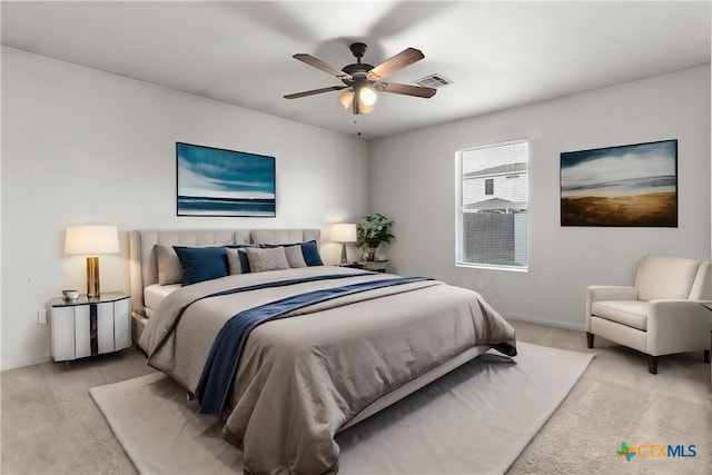 bedroom featuring baseboards, visible vents, ceiling fan, and light colored carpet