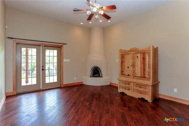 unfurnished living room with ceiling fan, french doors, dark hardwood / wood-style floors, and a fireplace