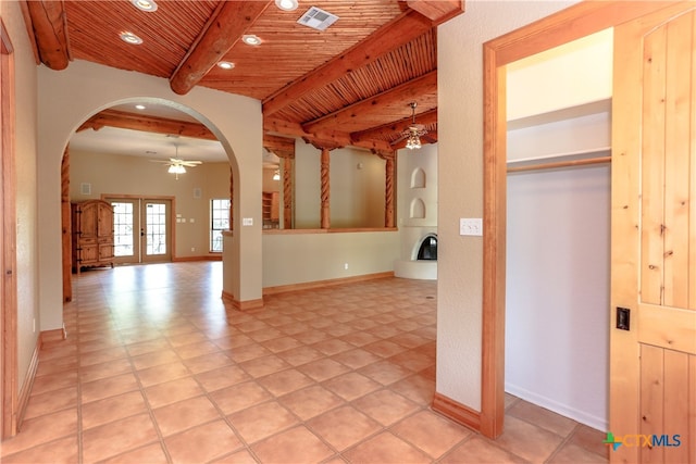 interior space featuring french doors, beam ceiling, wood ceiling, and light tile patterned floors