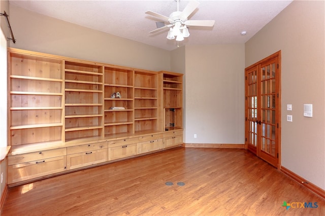 unfurnished living room featuring light hardwood / wood-style floors, ceiling fan, a textured ceiling, and french doors