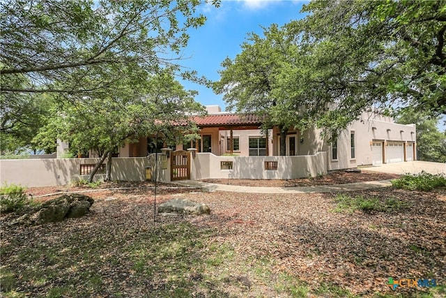 9776 Arroyo Dr, Belton, TX 76513 - rear view of house featuring a fenced front yard, stucco siding, a tiled roof, concrete driveway, and a garage