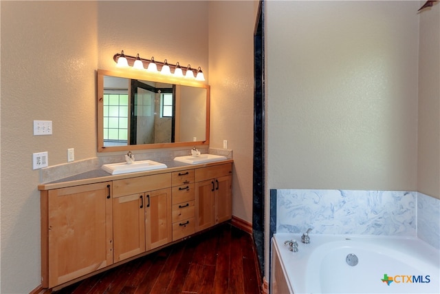 bathroom featuring hardwood / wood-style floors, a tub to relax in, and vanity