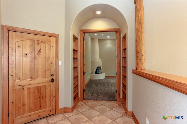 9776 Arroyo Dr, Belton, TX 76513 - foyer entrance featuring light carpet, arched walkways, baseboards, and light tile patterned floors