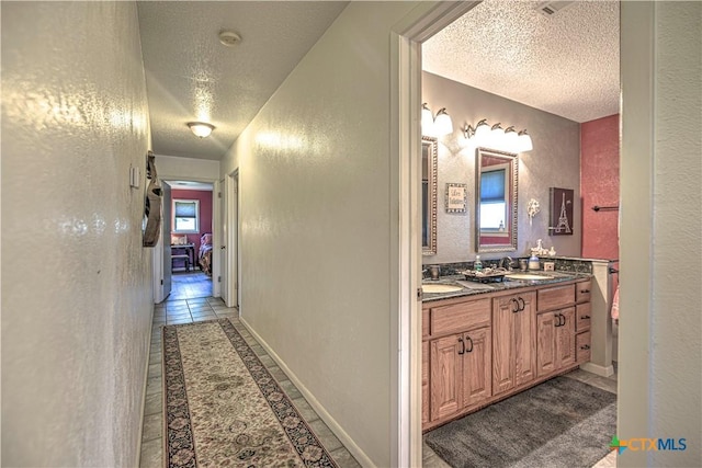 4701 Hickory Rd, Temple, TX 76502 - full bathroom featuring a textured ceiling, a textured wall, double vanity, and tile patterned flooring