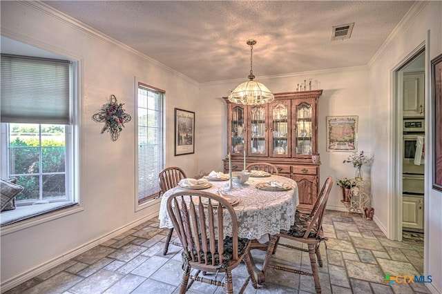 4701 Hickory Rd, Temple, TX 76502 - dining space with stone tile floors, a chandelier, baseboards, a textured ceiling, and ornamental molding