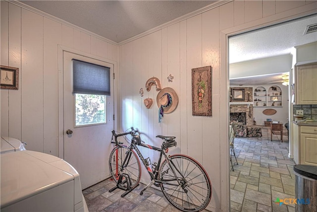 4701 Hickory Rd, Temple, TX 76502 - washroom featuring ornamental molding, a fireplace, washing machine and dryer, and light stone finish floors