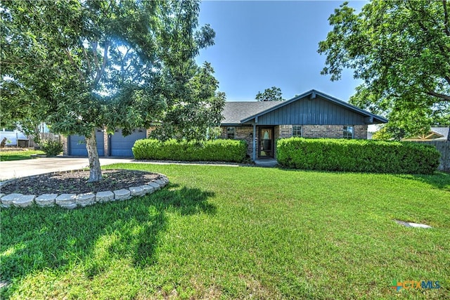 4701 Hickory Rd, Temple, TX 76502 - view of front of home featuring concrete driveway, a front lawn, brick siding, and a garage