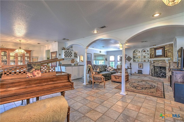 4701 Hickory Rd, Temple, TX 76502 - living area featuring decorative columns, a textured ceiling, crown molding, a fireplace, and arched walkways