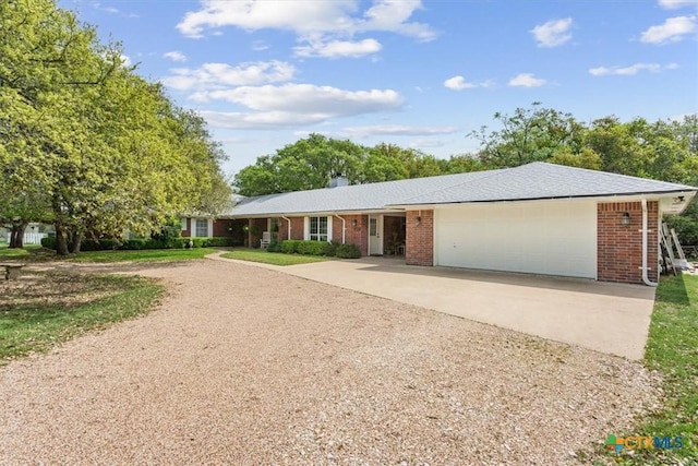 ranch-style house featuring brick siding, a garage, and concrete driveway