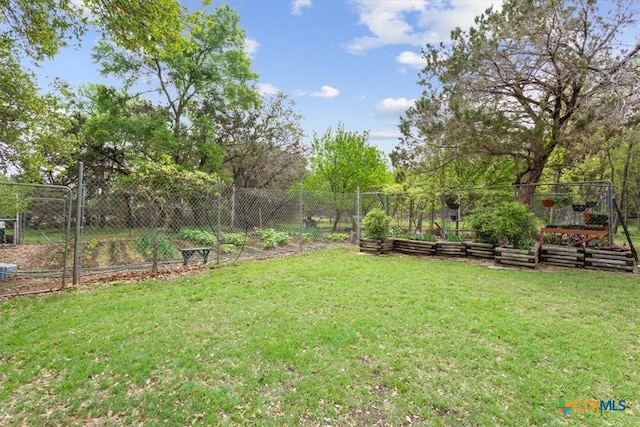 view of yard featuring fence and a vegetable garden
