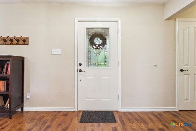 entryway featuring baseboards and wood finished floors