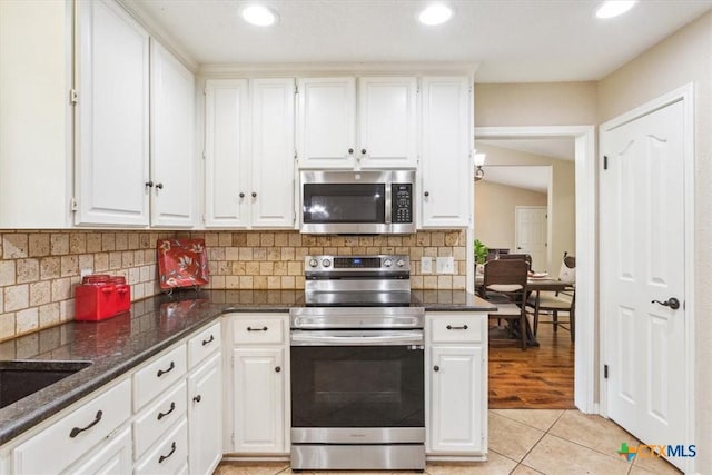 kitchen with white cabinets, recessed lighting, appliances with stainless steel finishes, backsplash, and light tile patterned floors