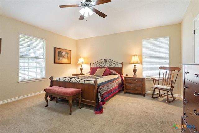 bedroom with a ceiling fan, light carpet, and baseboards