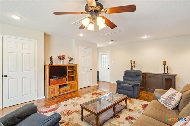 living area featuring light wood-style flooring, baseboards, recessed lighting, a ceiling fan, and attic access