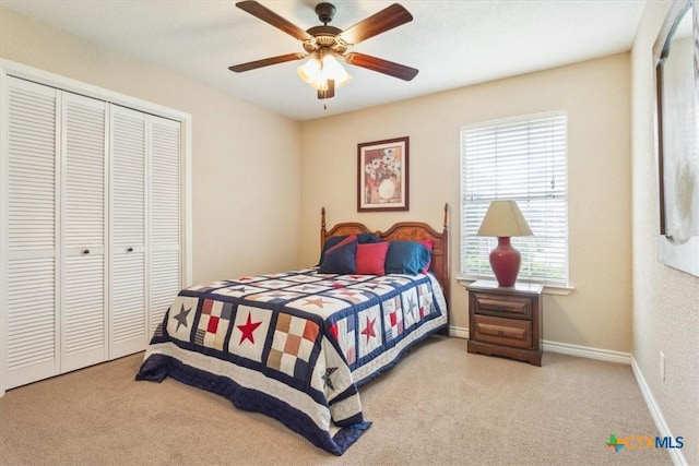 bedroom with baseboards, a closet, ceiling fan, and carpet flooring
