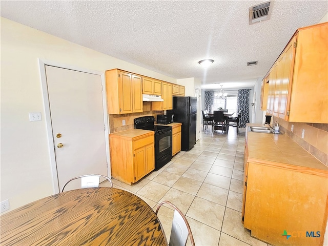 kitchen featuring black appliances, sink, a textured ceiling, tasteful backsplash, and light tile patterned flooring