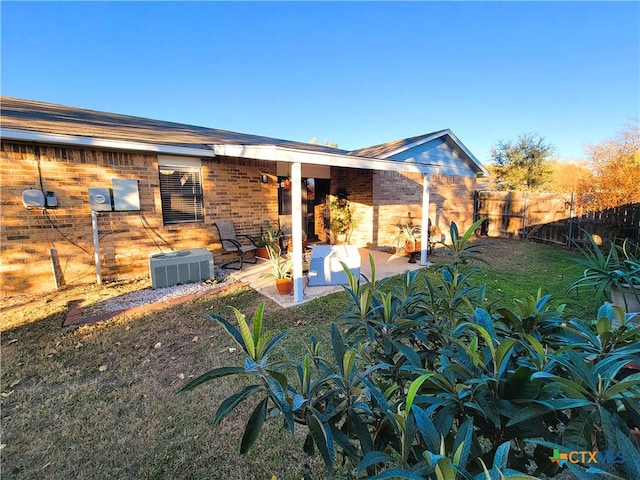 rear view of house with a lawn, a patio area, and central AC unit