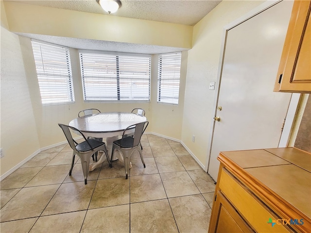 tiled dining space with a textured ceiling