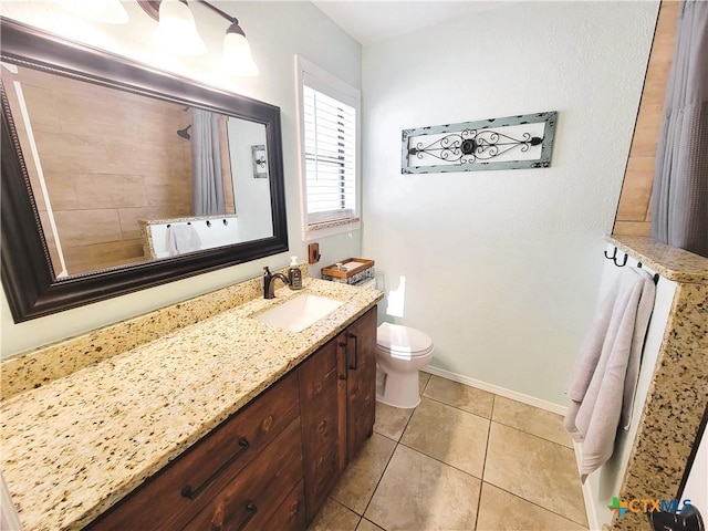 bathroom with tile patterned flooring, vanity, and toilet