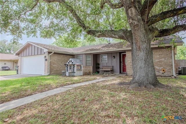 111 Lexington Ln, Victoria, TX 77901 - ranch-style house featuring an attached garage, brick siding, board and batten siding, and a front lawn