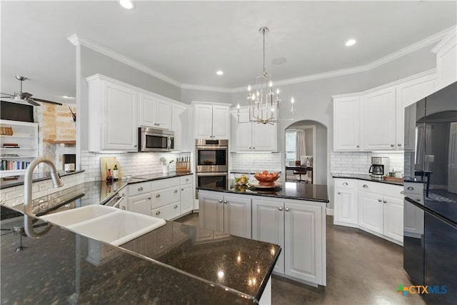 810 Pinnacle Pkwy, New Braunfels, TX 78132 - kitchen with black appliances, a sink, arched walkways, tasteful backsplash, and finished concrete floors