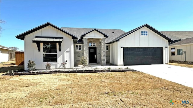 modern farmhouse style home with board and batten siding, driveway, an attached garage, and fence