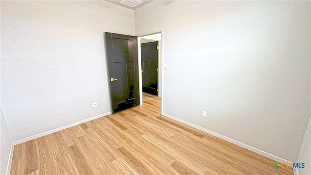 empty room with light wood-style flooring and baseboards