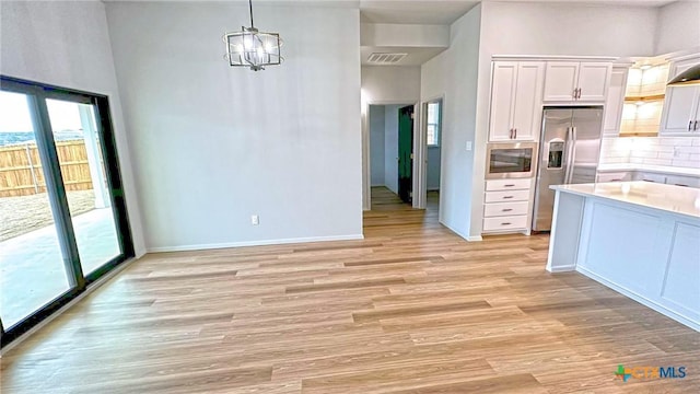 kitchen featuring stainless steel appliances, plenty of natural light, white cabinetry, and light wood-style floors