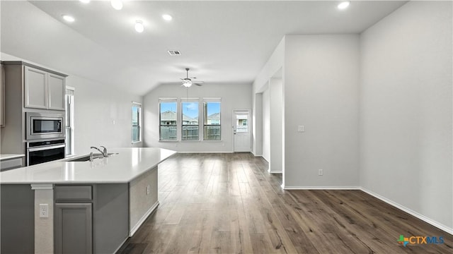 3938 Legend Park, New Braunfels, TX 78130 - kitchen featuring appliances with stainless steel finishes, gray cabinetry, open floor plan, dark wood-style flooring, and light countertops