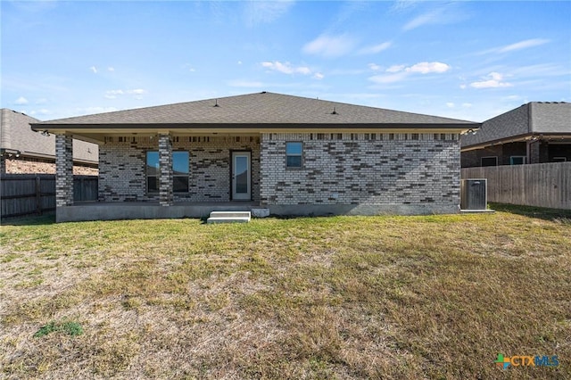 back of property with a lawn and cooling unit