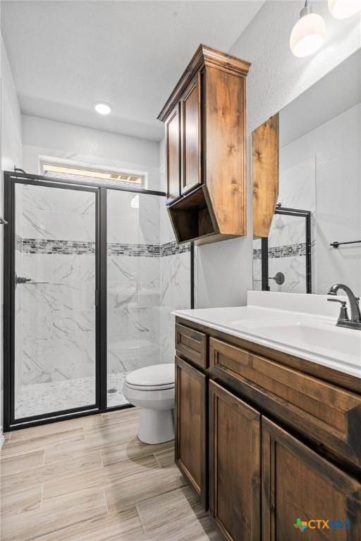 bathroom with toilet, vanity, and walk in shower