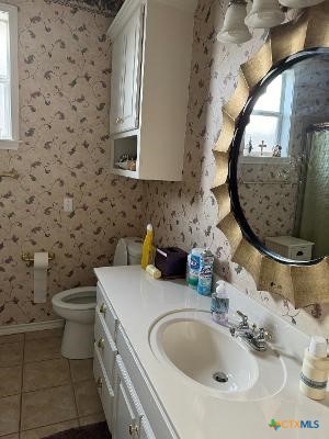 bathroom with tile patterned floors, vanity, and toilet