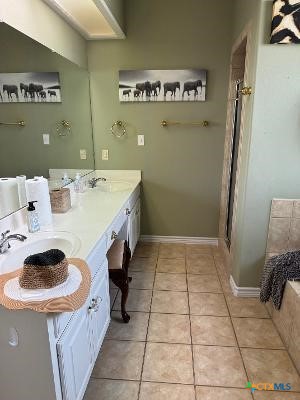 bathroom featuring tile patterned floors, a bathing tub, and vanity