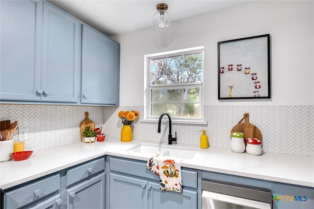 kitchen with dishwasher, tasteful backsplash, blue cabinets, and sink