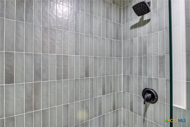 interior details with a tile shower