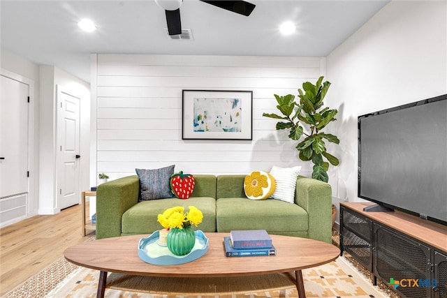 living room featuring hardwood / wood-style floors and ceiling fan