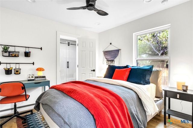 bedroom featuring baseboard heating, ceiling fan, and wood-type flooring