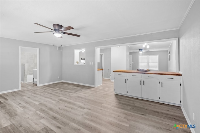 unfurnished living room with ornamental molding, ceiling fan, and light hardwood / wood-style floors