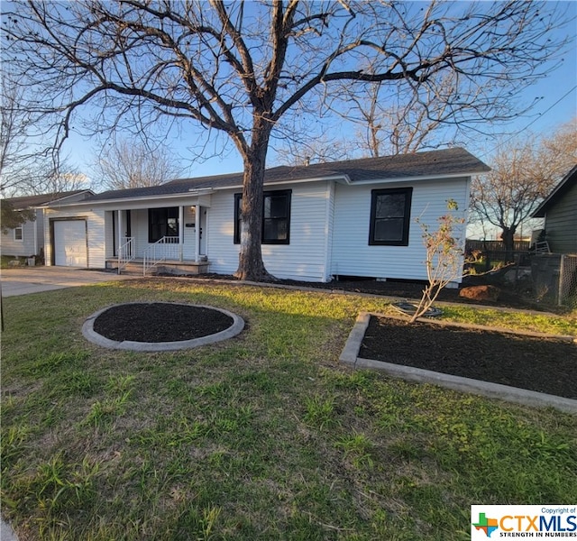 ranch-style home with a garage, a front lawn, and covered porch