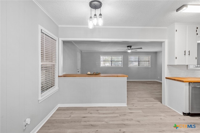 kitchen with decorative backsplash, wood counters, white cabinetry, light hardwood / wood-style flooring, and decorative light fixtures