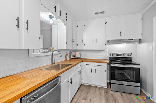 kitchen with stainless steel appliances, light hardwood / wood-style floors, sink, white cabinets, and exhaust hood