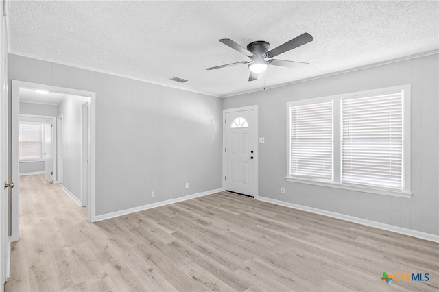 foyer featuring ceiling fan, a textured ceiling, light hardwood / wood-style flooring, and crown molding