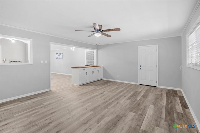 unfurnished living room with ceiling fan, crown molding, and light hardwood / wood-style flooring