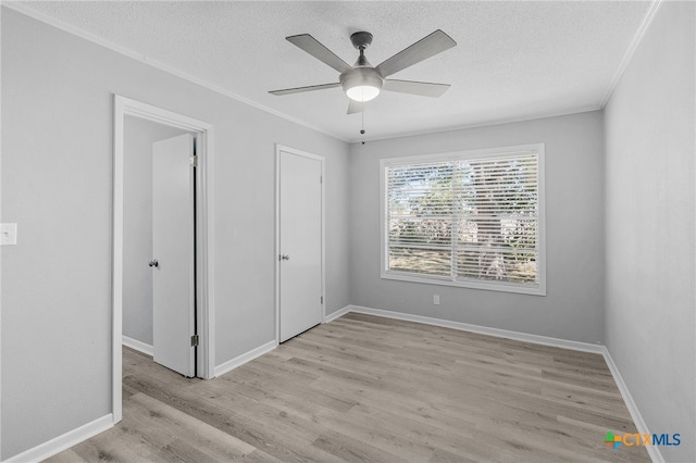 unfurnished bedroom with ornamental molding, ceiling fan, a textured ceiling, and light hardwood / wood-style floors