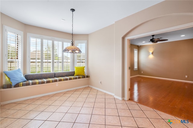 unfurnished dining area featuring light wood-type flooring and ceiling fan