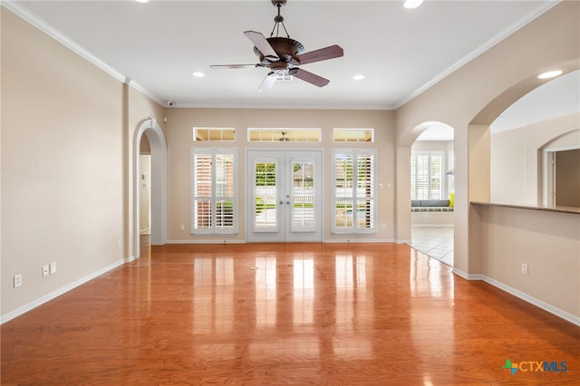 empty room with ceiling fan, light wood-type flooring, and crown molding