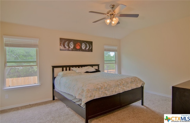 carpeted bedroom with multiple windows, lofted ceiling, and ceiling fan